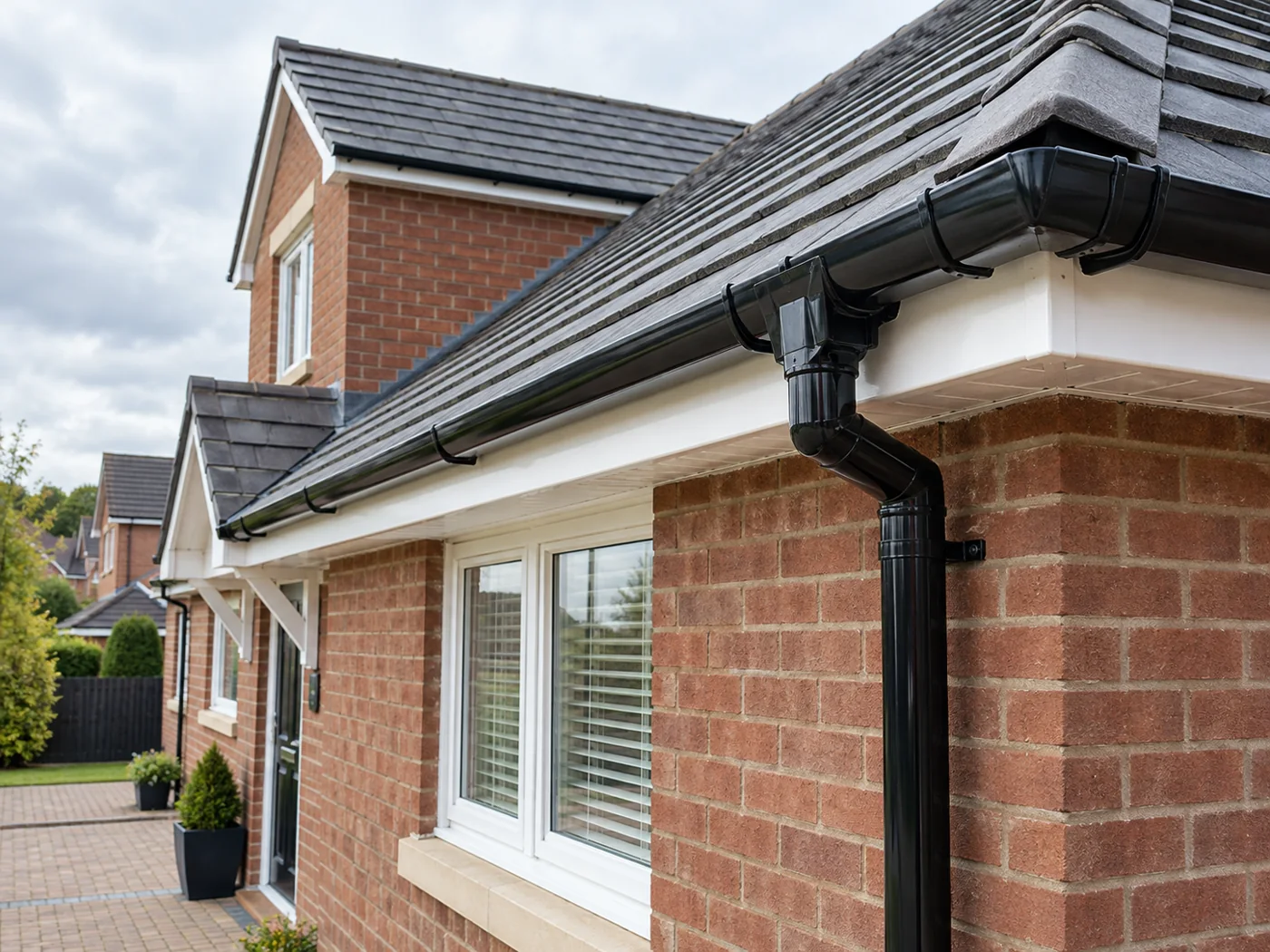 Guttering, fascia and downpipe beneath domestic roof eaves