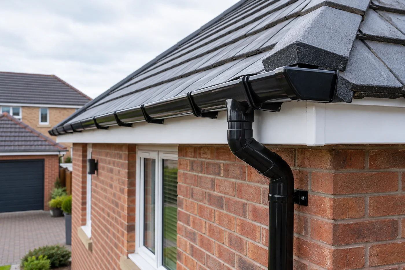 Guttering, fascia and downpipe beneath domestic roof eaves