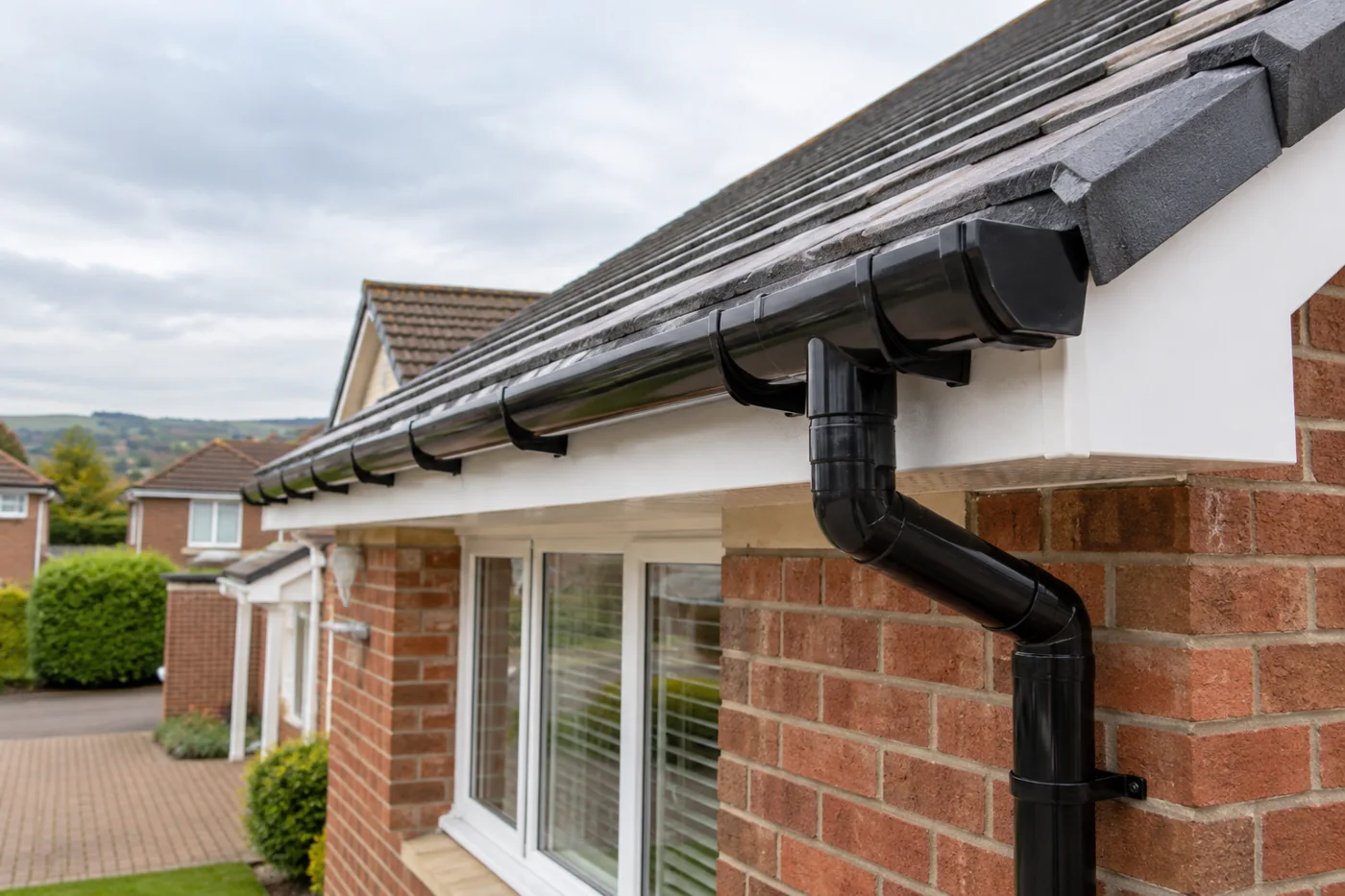 Guttering, fascia and downpipe beneath domestic roof eaves